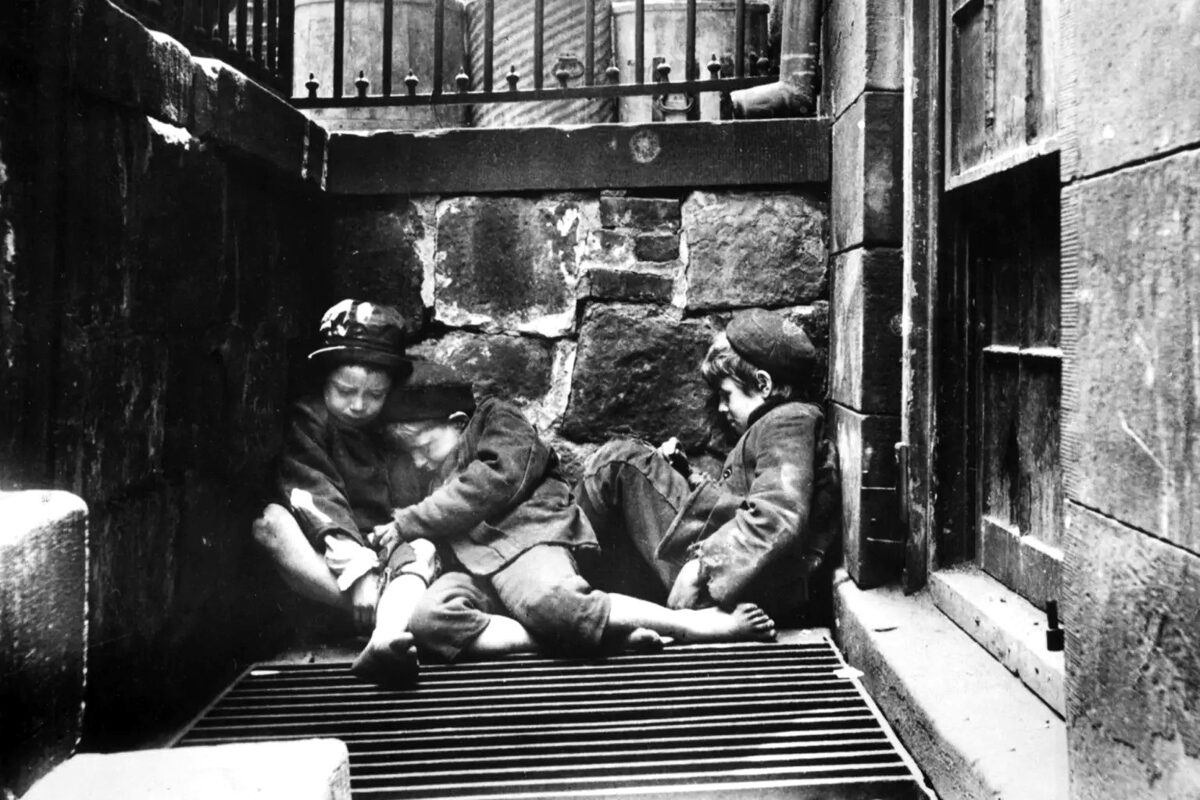 Tre gadebørn kryber sammen for at få varmen på Mulberry Street i New York. Foto Jacob A. Riis