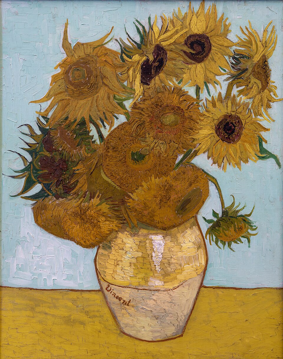 Vincent van Goghs maleri Vase med tolv solsikker (1888): tolv solsikker i alle stadier fra fuldt flor til visnende i en lys gul lervase signeret Vincent, på en okkergul bordflade foran en lyseblå baggrund.